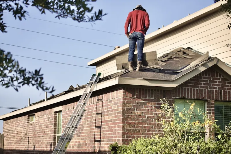 Professional roofer working on a residential roof in Grasselli